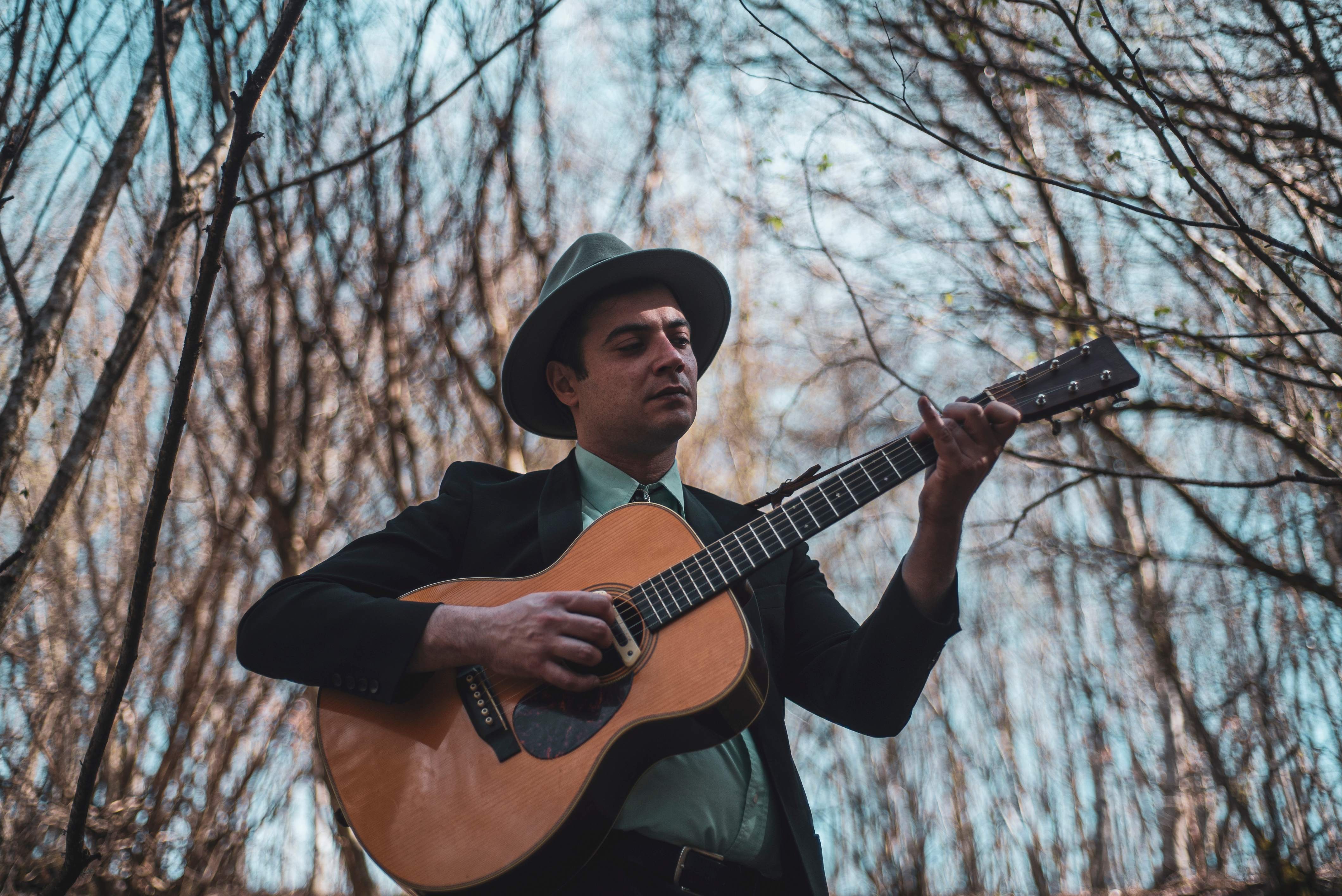Andrea Baldoffei playing guitar in a forest